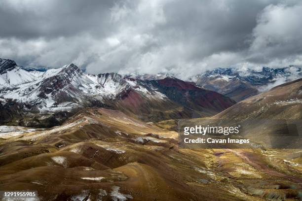scenic view of valley amongst high andes mountains on rainbow mountain trail, pitumarca, peru - vinicunca photos et images de collection