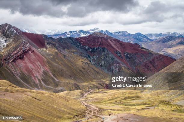scenic view of valley amongst high andes mountains on rainbow mountain trail, pitumarca, peru - vinicunca fotografías e imágenes de stock