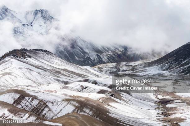 snowcapped mountain peaks in the andes covered with fog rising above the valley, rainbow mountain trail, pitumarca, peru - vinicunca photos et images de collection