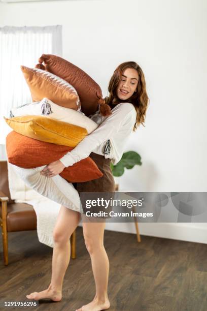 girl walking with her stack of fall pillows - tidy room fotografías e imágenes de stock