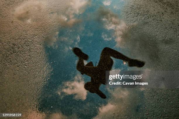 reflection in water of female athlete running. - running shoes sky ストックフォトと画像