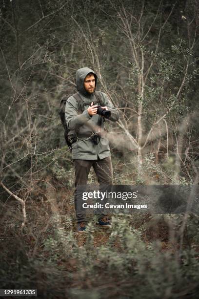 photographer camouflaged on nature between bushes raising the camera - woodland camo stock pictures, royalty-free photos & images