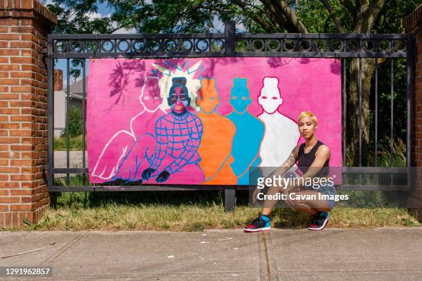a young female artists sits proudly in front of her street painting - street art stock pictures, royalty-free photos & images