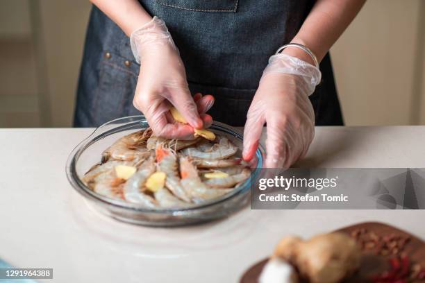 woman ordering fresh prawn for cooking in the glass bowl - gloves stock pictures, royalty-free photos & images