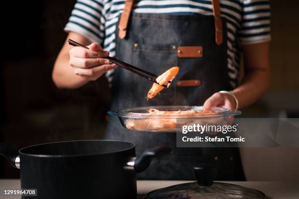 woman collecting fresh boiled shrimps from the pot - scampi stock pictures, royalty-free photos & images