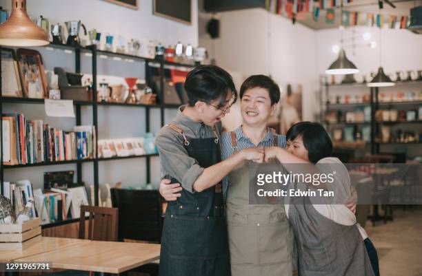 asian cafe down syndrome disability employee and owner fist bump bonding time in cafe happily - small business stock pictures, royalty-free photos & images