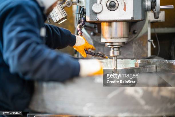 a worker in a factory working on a traditional milling machine - manufacturing stock pictures, royalty-free photos & images