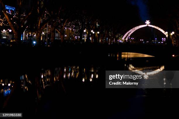 reflection of christmas decorations in a river amidst a shopping street. - glow düsseldorf stock-fotos und bilder