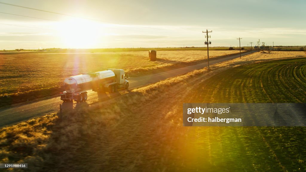 Aerial Shot of Milk Tanker on Country Road with Dramatic Lens Flare