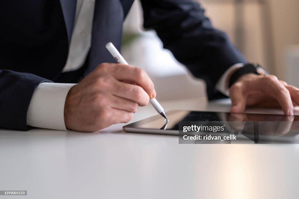 Businessman Signing Digital Contract On Tablet Using Stylus Pen