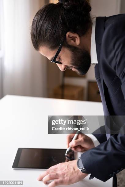 businessman signing digital contract on tablet using stylus pen - signing tablet stock pictures, royalty-free photos & images
