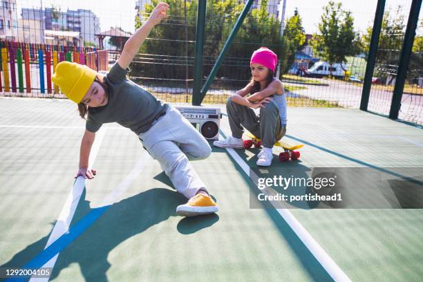 two children listening music, having fun and dancing on a playground - break dancer stock pictures, royalty-free photos & images