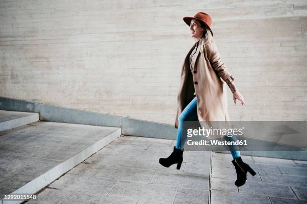 beautiful smiling woman running up on steps by wall - 階段　のぼる ストックフォトと画像