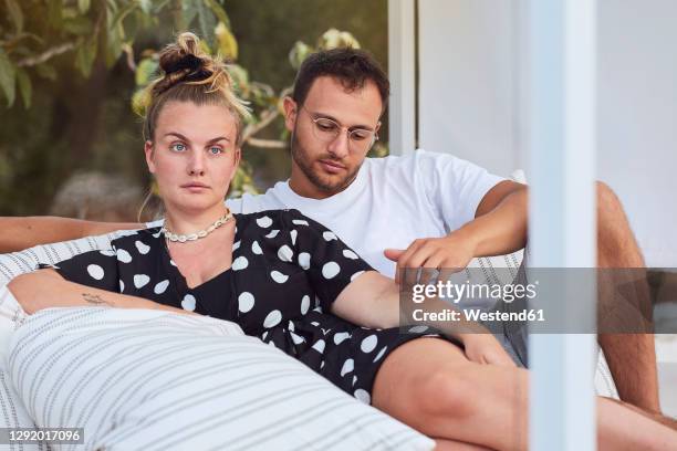 affectionate young couple relaxing on sofa in back yard - bored girlfriend stock pictures, royalty-free photos & images