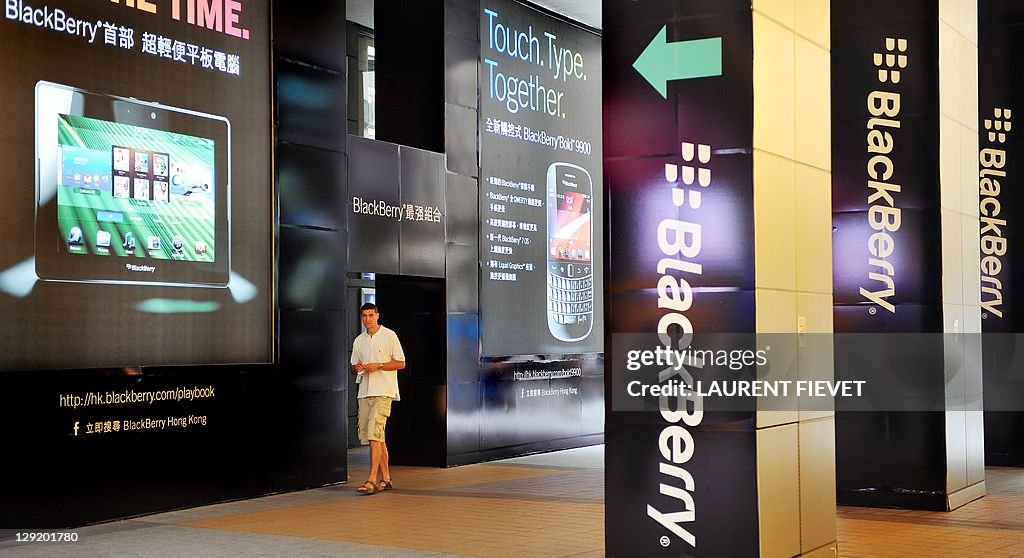 A man walks past a large BlackBerry adve
