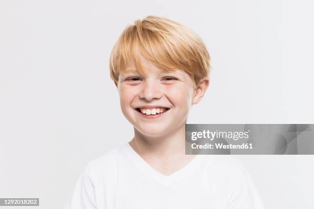 cheerful cute boy with blond hair against white background - boy happy blonde stock pictures, royalty-free photos & images