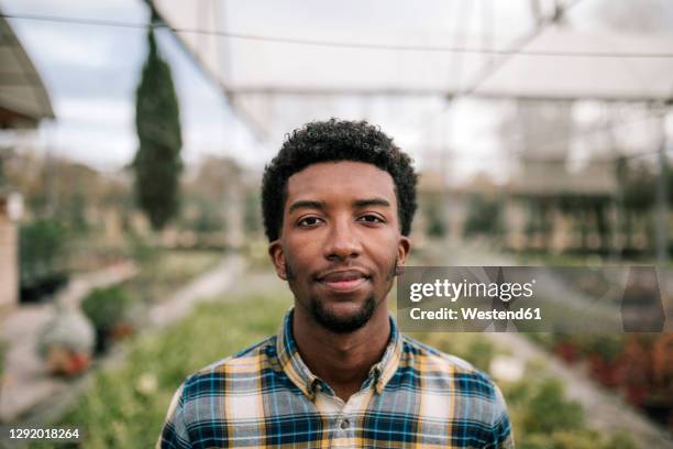 young african male farmer at plant nursery - african male portrait fotografías e imágenes de stock