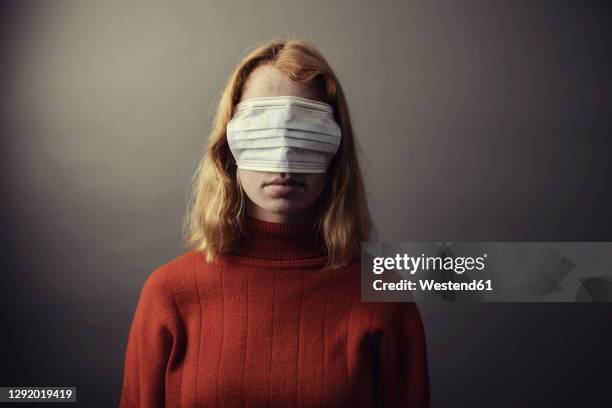 teenage girl wearing protective face mask on eyes while standing against gray background - dumb blonde stock pictures, royalty-free photos & images