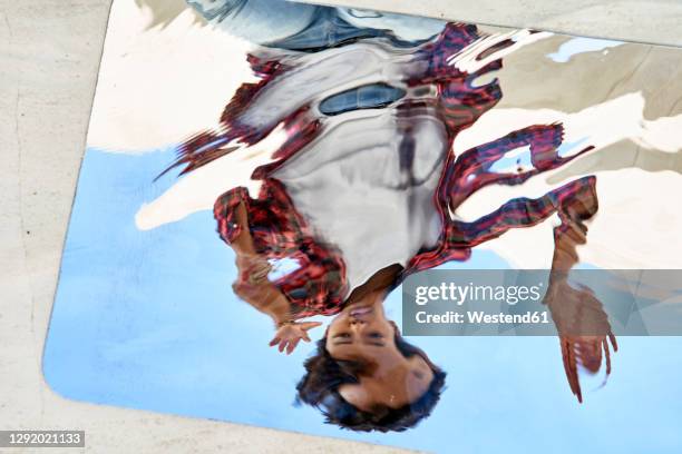 distorted reflection of young woman on mirror - distorted stock pictures, royalty-free photos & images