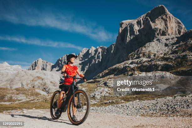 adventurous cyclist looking away at picos de europa national park during weekend, cantabria, spain - picos de europe stock pictures, royalty-free photos & images