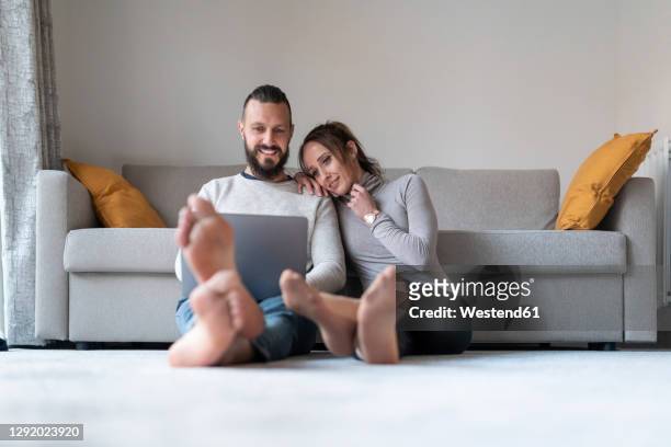 woman leaning on shoulder of boyfriend while watching movie on laptop at home - lovers 2020 film fotografías e imágenes de stock