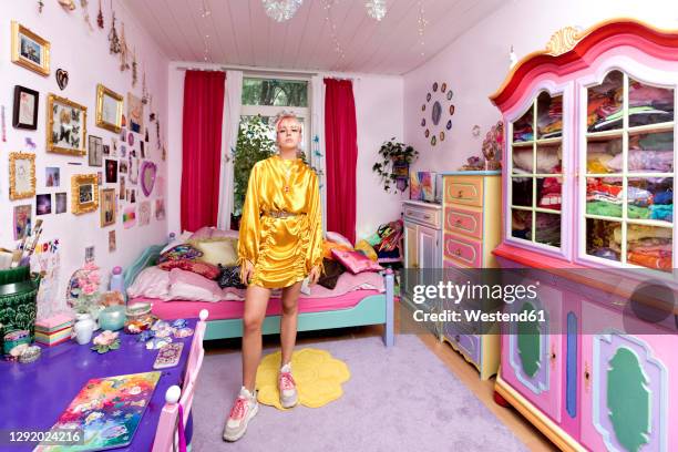 beautiful woman wearing yellow dress in flashy bedroom at home - colorful shoes stockfoto's en -beelden