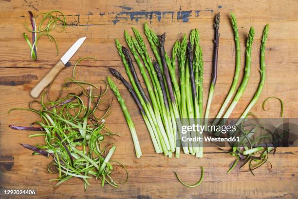 kitchen knife and freshly peeled asparagus stalks - geschält stock-fotos und bilder