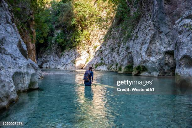 man hiking through acheron river at epirus, greece - epirus greece stock pictures, royalty-free photos & images