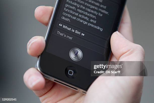 Man uses 'Siri' on the new iPhone 4S after being one of the first customers in the Apple store in Covent Garden on October 14, 2011 in London,...