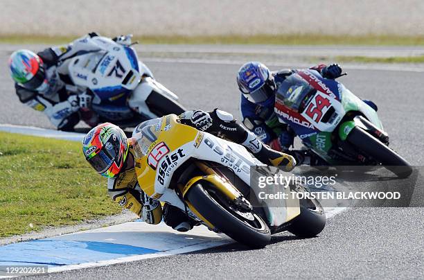 Motobi rider Alex de Angelis of San Marino powers ahead of Kenan Sofuoglu of Turkey and Claudio Corti of Italy during the second practice session of...