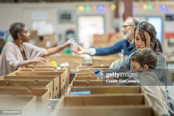 voluntarios en un banco de alimentos - food pantry fotografías e imágenes de stock