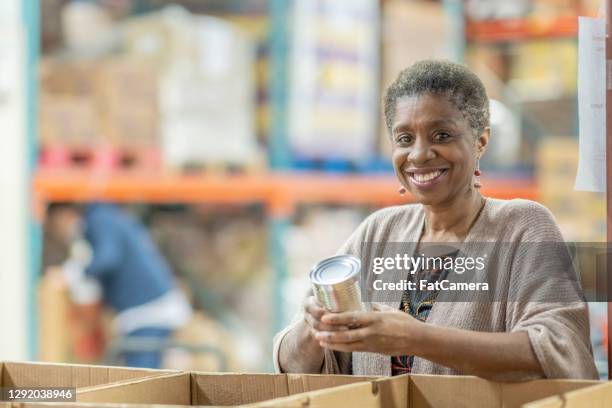 volunteers at a food bank - hunger food bank stock pictures, royalty-free photos & images