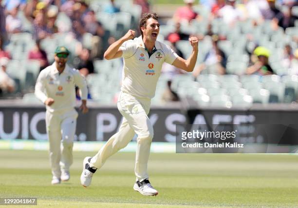 Pat Cummins of Australia celebrates after taking the wicket of Virat Kohli of India during day three of the First Test match between Australia and...