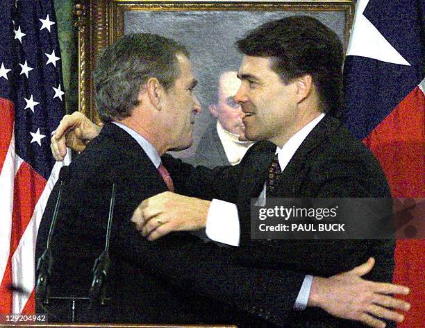 President-elect George W. Bush gets a hug from Texas Lt. Governor Rick Perry following his resignation announcement in the Senate Chamber at the...