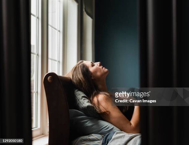mirror reflection of woman laying on a bed in a dark bedroom. - woman 45 sleeping stock pictures, royalty-free photos & images