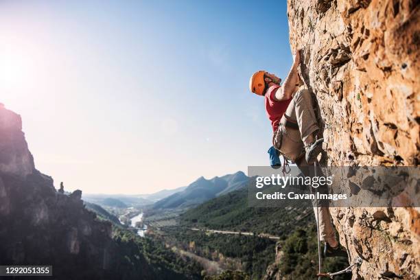 a climber with a landscape in the background - soloklettern stock-fotos und bilder