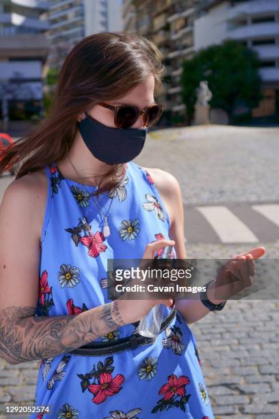 woman outdoors during covid with mask and alcohol - woman in cobalt blue dress stock pictures, royalty-free photos & images