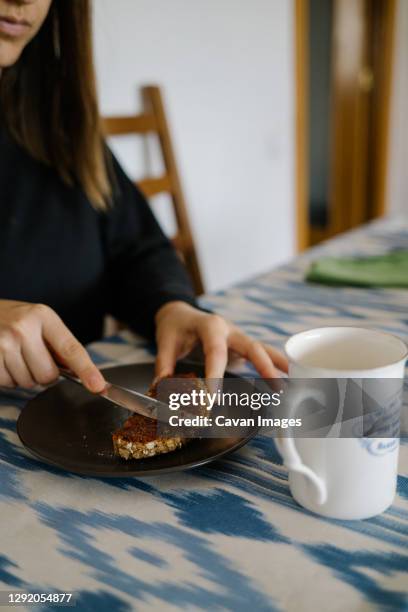 girl spreading a slice of bread with vegan pate - untar de mantequilla fotografías e imágenes de stock