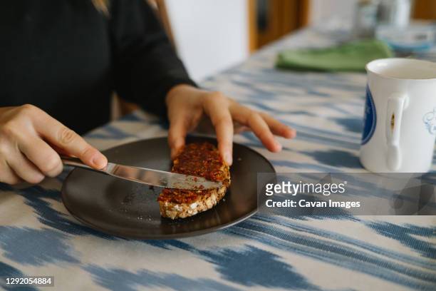 girl spreading a slice of bread with vegan pate - buttering stock pictures, royalty-free photos & images