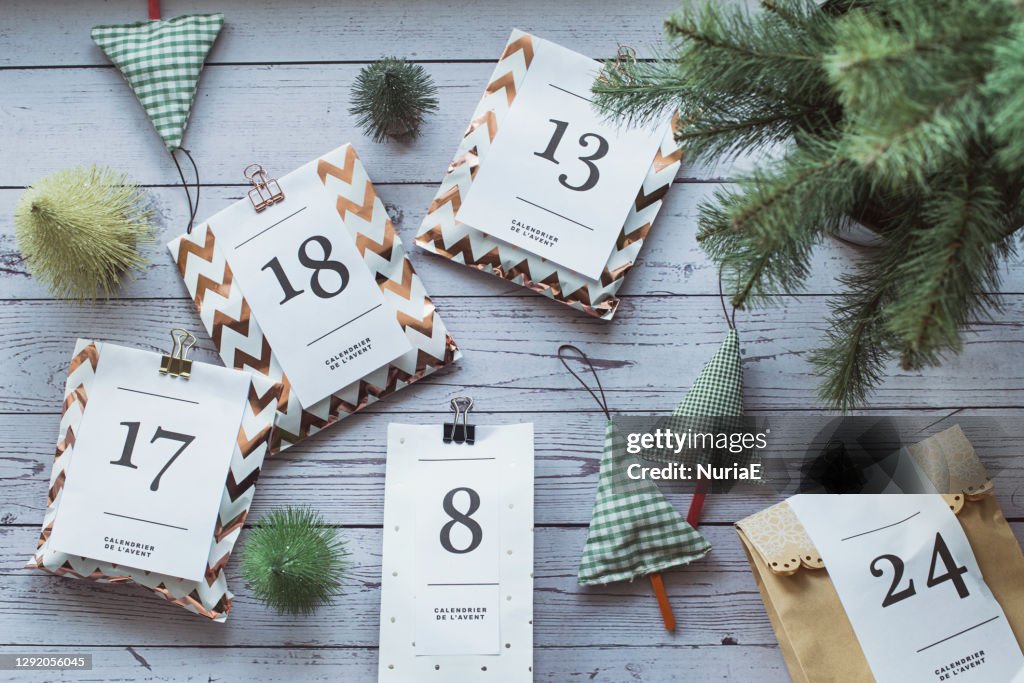 Overhead view of gifts for an advent calendar next to Christmas decorations
