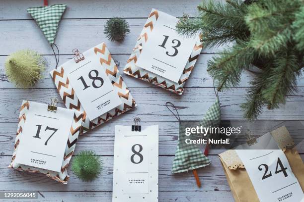 overhead view of gifts for an advent calendar next to christmas decorations - aftellen stockfoto's en -beelden