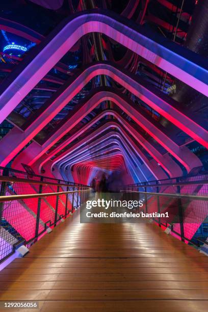 abstract shot of people walking across a pedestrian bridge at night, jakarta, indonesia - illuminated bridge stock pictures, royalty-free photos & images