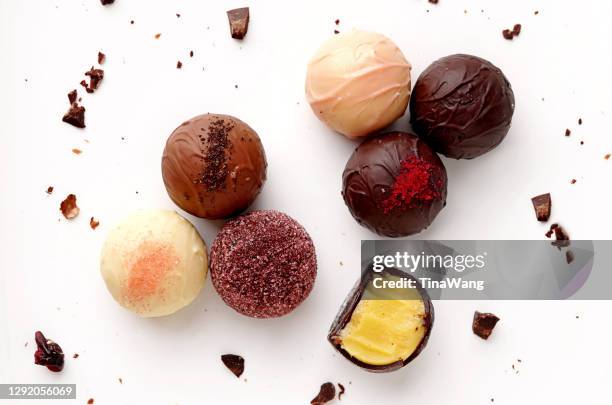 overhead view of mixed chocolate truffles on a  table with chocolate flakes - confectionery fotografías e imágenes de stock