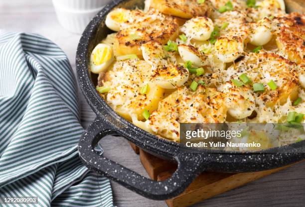 fried potatoes in a pan on a wooden table background. - baking pan stock pictures, royalty-free photos & images