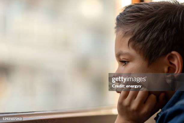 kind dat uit venster kijkt - refugees stockfoto's en -beelden