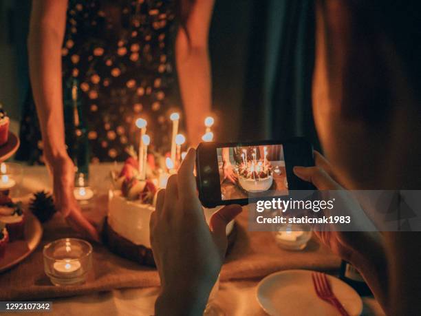 felices amigos asiáticos celebrando el cumpleaños con pastel en casa. - 25° aniversario fotografías e imágenes de stock