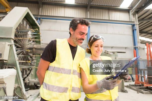 mitarbeiterpaar überprüft das inventar und das notizbuch mit bauanleitungen - ärmellos stock-fotos und bilder