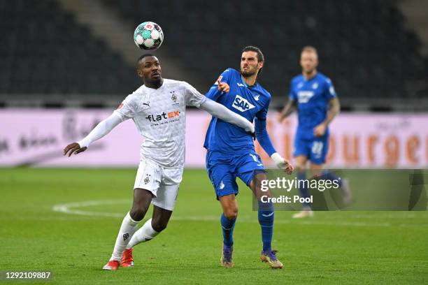 Marcus Thuram of Borussia Monchengladbach is challenged by Florian Grillitsch of Hoffenheim during the Bundesliga match between Borussia...