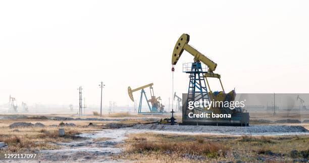 oliepompen die onder de hemel werken - working oil pumps stockfoto's en -beelden