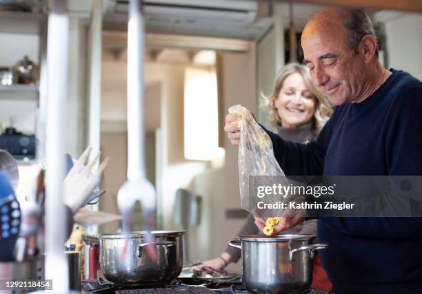 mature couple making a soup together - middle aged couple cooking ストックフォトと画像